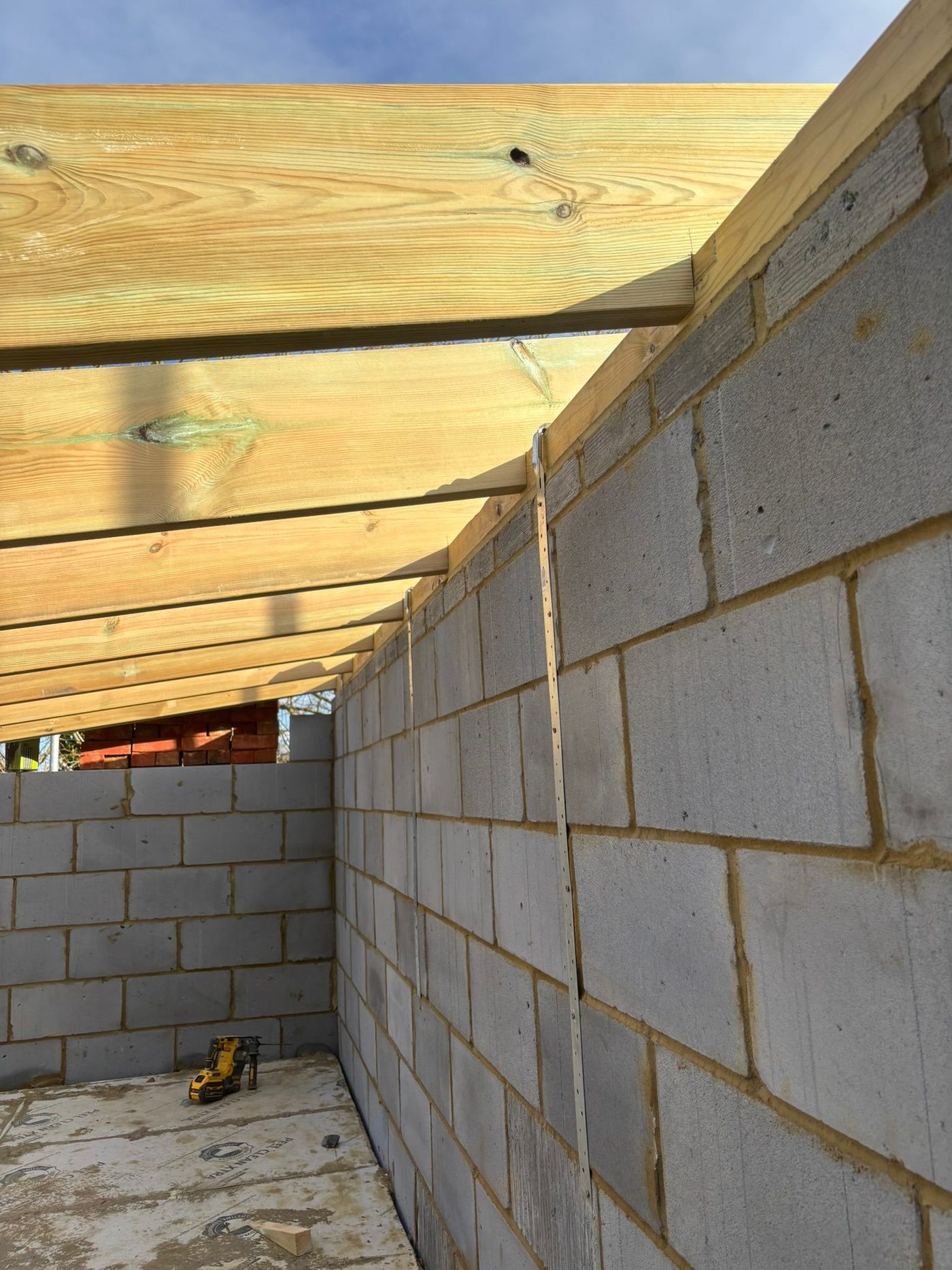 Close-up of timber joist fixed to block wall
